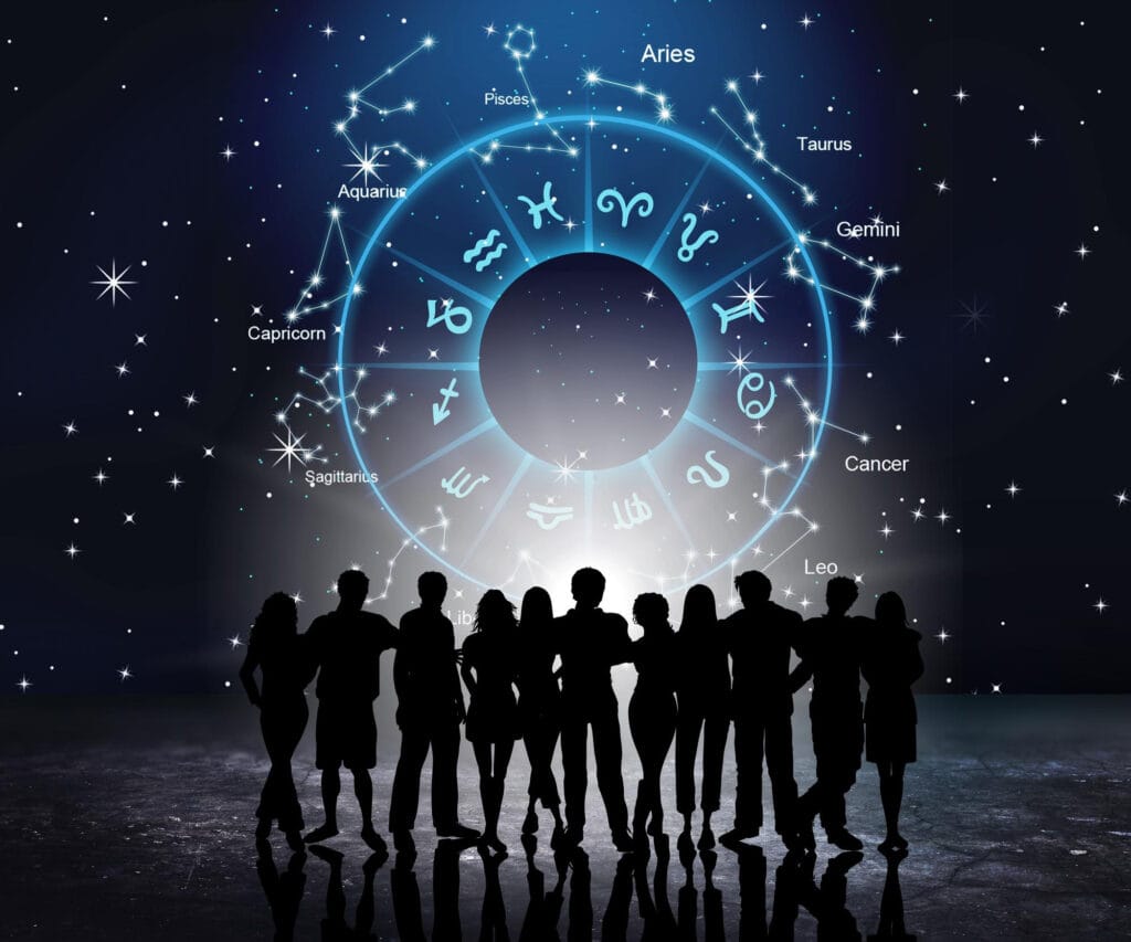 People gathered in front of a large astrology chart wheel